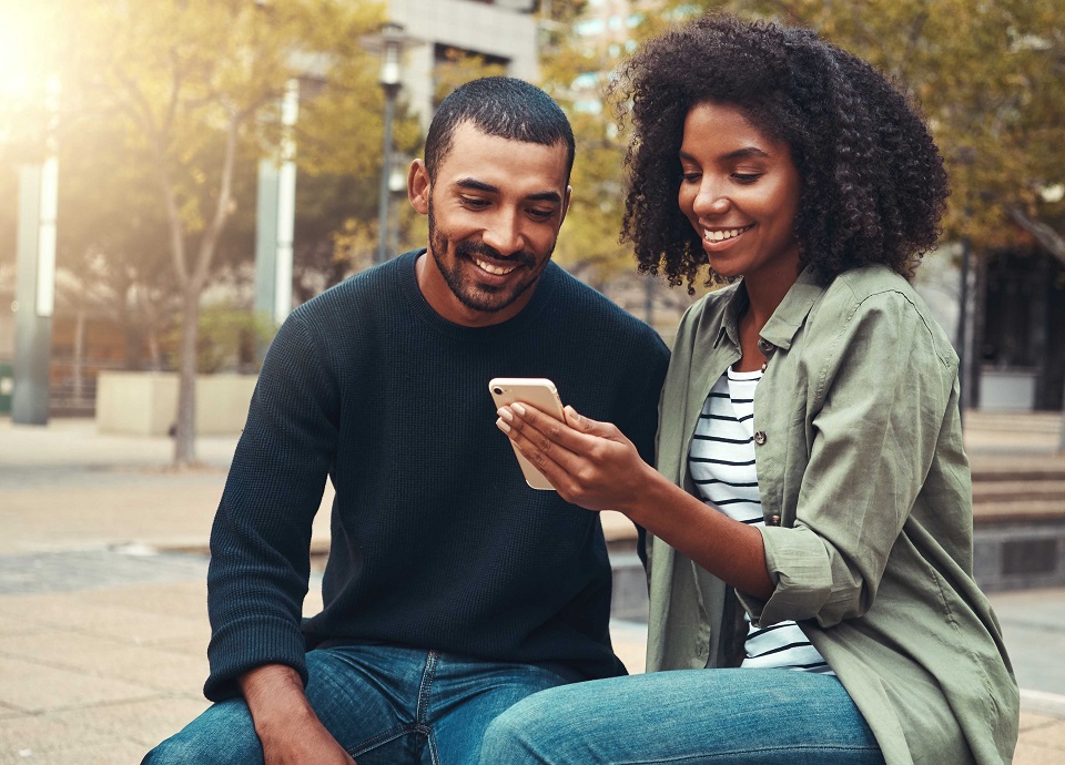 Young,Couple,Looking,At,Mobile,Phone